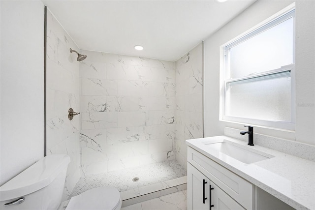 bathroom featuring toilet, marble finish floor, a shower stall, and vanity