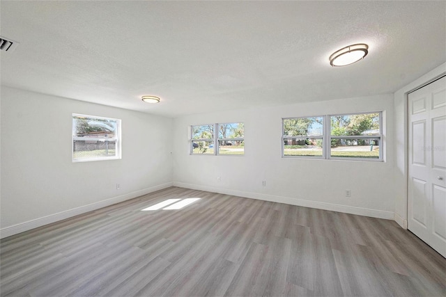 interior space with a wealth of natural light, light wood-style flooring, and baseboards