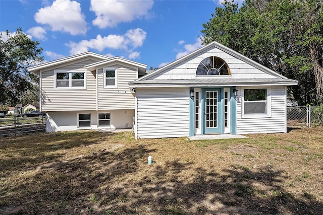 back of house with fence and a lawn