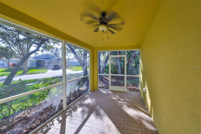 unfurnished sunroom featuring ceiling fan