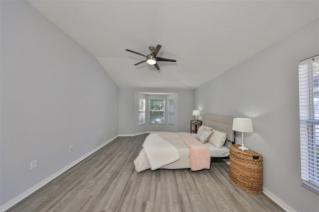 bedroom with hardwood / wood-style flooring, ceiling fan, and multiple windows