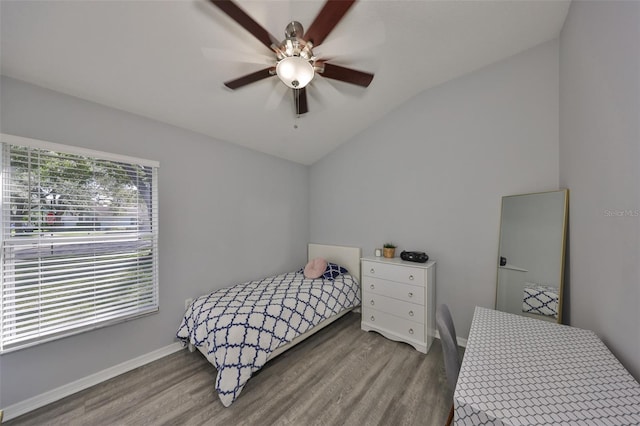 bedroom with ceiling fan, vaulted ceiling, and hardwood / wood-style floors