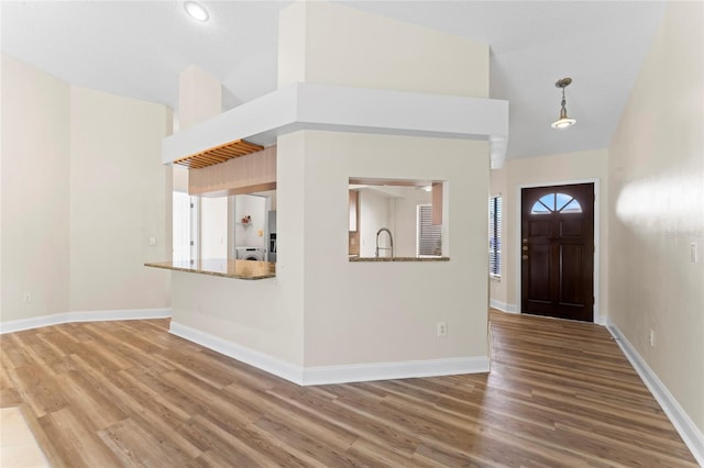 foyer with washer / clothes dryer, sink, wood-type flooring, and high vaulted ceiling