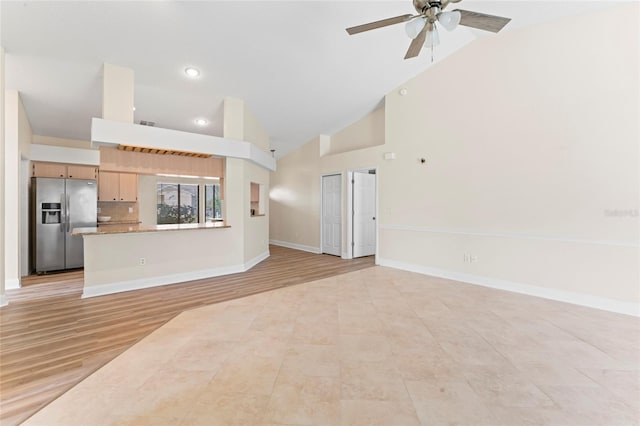 unfurnished living room with ceiling fan, high vaulted ceiling, and light hardwood / wood-style flooring