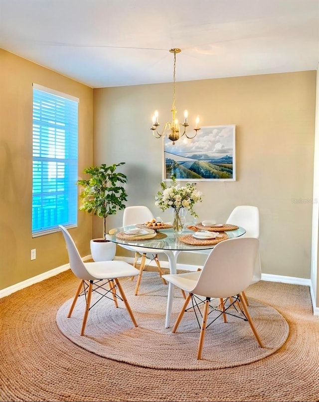 dining space with an inviting chandelier and carpet floors