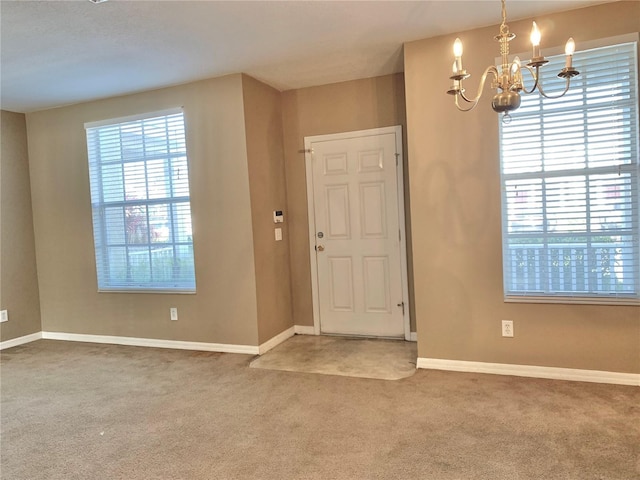 entryway featuring carpet flooring and a chandelier