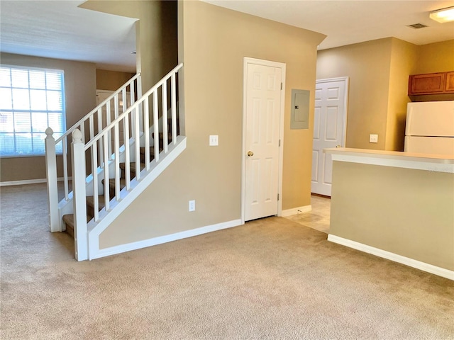 unfurnished living room featuring light carpet and electric panel