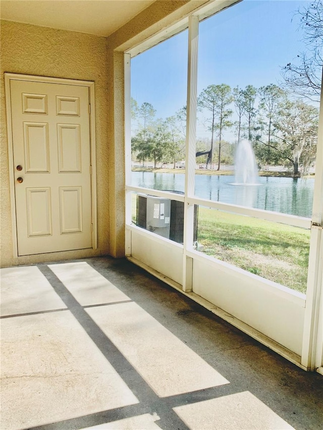 unfurnished sunroom featuring a water view