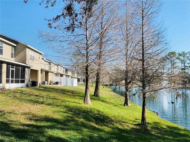 view of yard with a water view and central AC unit