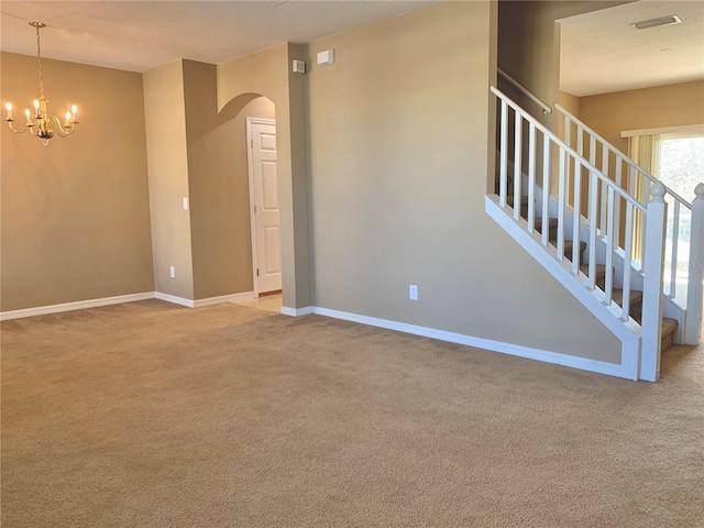 unfurnished room featuring light carpet and a notable chandelier