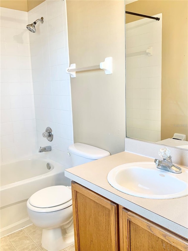 full bathroom with tile patterned flooring, tiled shower / bath, vanity, and toilet