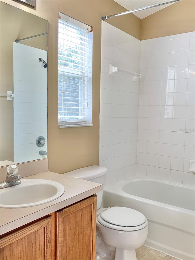 full bathroom with tile patterned flooring, vanity, tiled shower / bath combo, and toilet