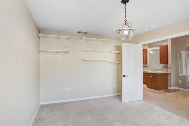 unfurnished bedroom featuring light carpet, sink, and connected bathroom