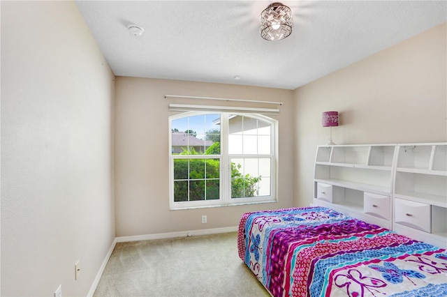 bedroom featuring light colored carpet and a textured ceiling