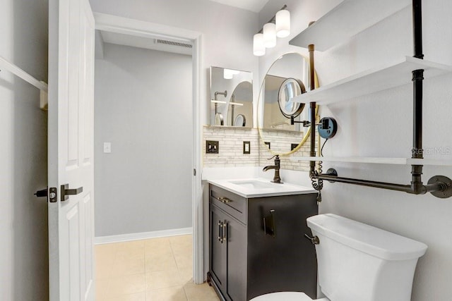 bathroom with tasteful backsplash, vanity, tile patterned floors, and toilet