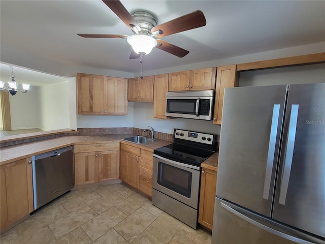 kitchen with sink, ceiling fan with notable chandelier, and appliances with stainless steel finishes