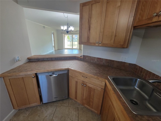 kitchen featuring pendant lighting, sink, stainless steel dishwasher, and an inviting chandelier