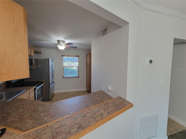 kitchen featuring stainless steel appliances, sink, ceiling fan, and kitchen peninsula