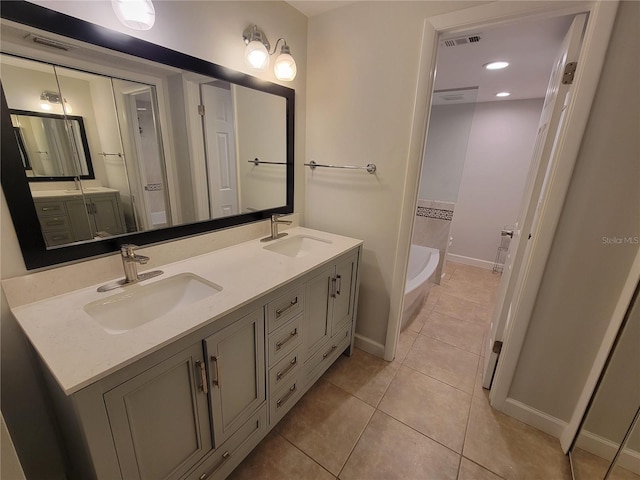 bathroom with tile patterned flooring, vanity, and a washtub