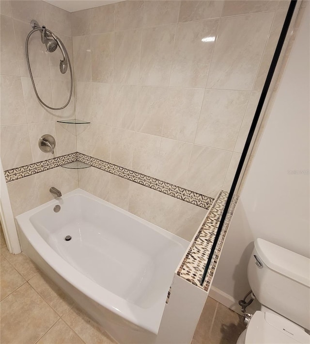 bathroom with tile patterned flooring, tiled shower / bath combo, and toilet