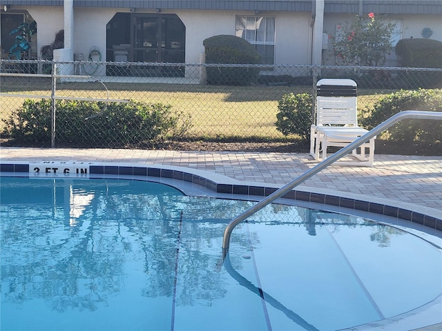 view of pool featuring a lawn