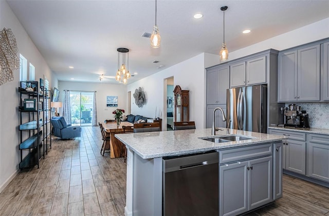 811 Winterside Dr, Apollo Beach, FL 33572 - kitchen with gray cabinets, appliances with stainless steel finishes, open floor plan, hanging light fixtures, and recessed lighting