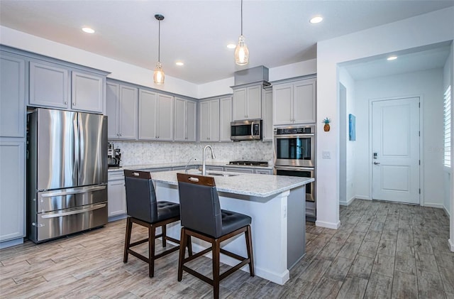 811 Winterside Dr, Apollo Beach, FL 33572 - kitchen featuring appliances with stainless steel finishes, gray cabinetry, decorative backsplash, light wood finished floors, and recessed lighting