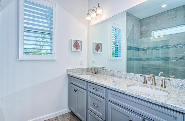 811 Winterside Dr, Apollo Beach, FL 33572 - full bath with plenty of natural light, double vanity, a tile shower, and wood finished floors