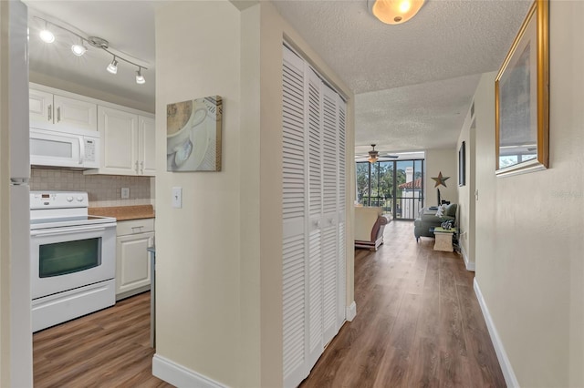 corridor with hardwood / wood-style flooring and a textured ceiling