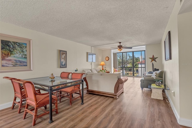 dining area with hardwood / wood-style flooring, ceiling fan, and a textured ceiling