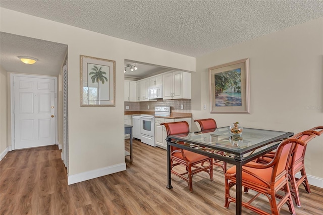 dining room with a textured ceiling and light wood-type flooring