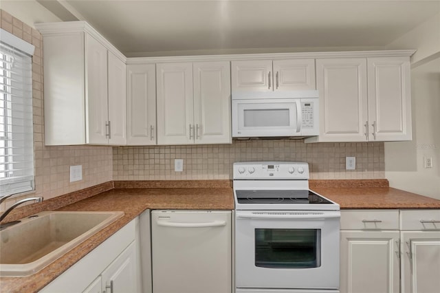 kitchen featuring tasteful backsplash, sink, white cabinets, plenty of natural light, and white appliances