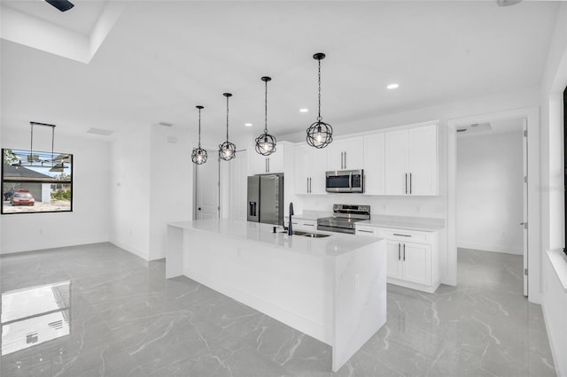 kitchen with white cabinetry, sink, hanging light fixtures, stainless steel appliances, and a center island with sink