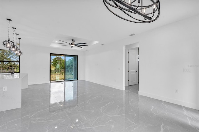 spare room with sink, a raised ceiling, and ceiling fan