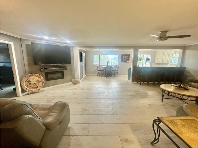 living room with ceiling fan and ornamental molding