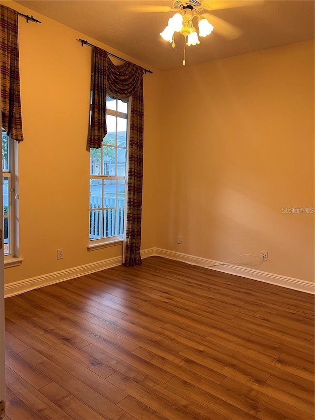 spare room with dark wood-type flooring and ceiling fan