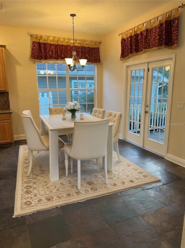 dining space with french doors and a chandelier