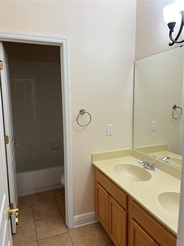 full bathroom with tiled shower / bath combo, vanity, tile patterned floors, and toilet