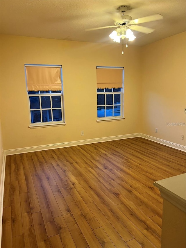 empty room featuring ceiling fan and hardwood / wood-style floors