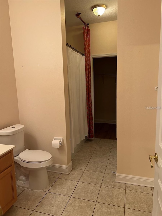 bathroom with tile patterned floors, vanity, toilet, and a textured ceiling