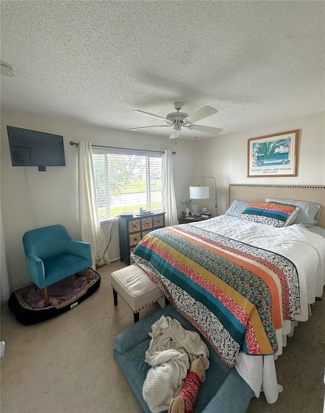 bedroom with carpet floors, a textured ceiling, and a ceiling fan