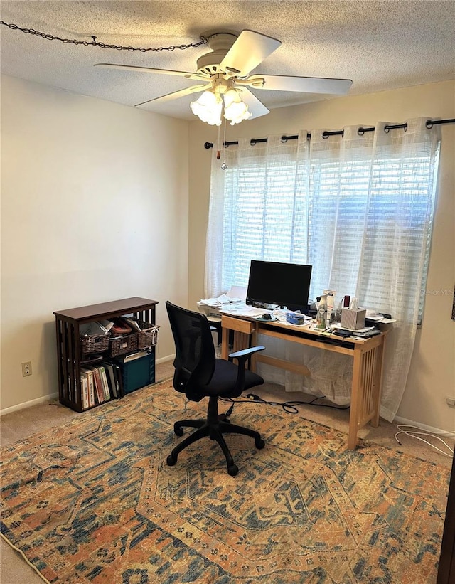 office featuring a ceiling fan, carpet, a textured ceiling, and baseboards