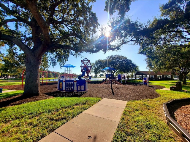 view of property's community featuring playground community and a yard