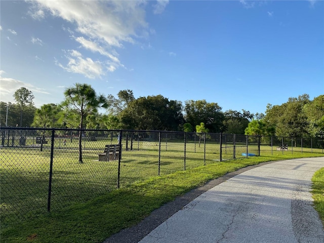 view of home's community with a lawn and fence