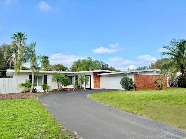 single story home with a garage, aphalt driveway, and a front yard