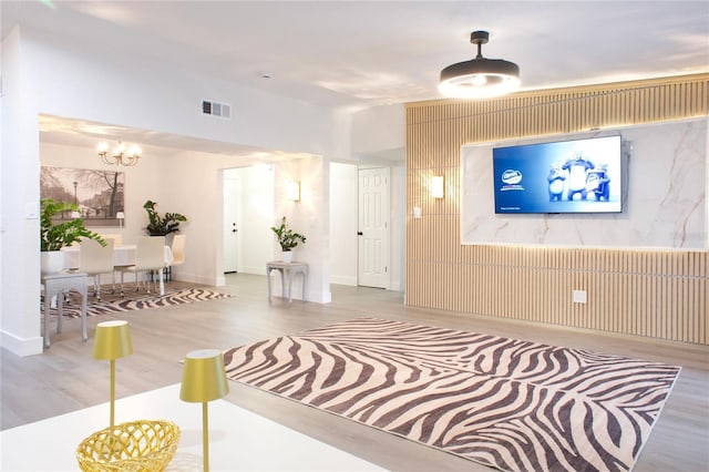 entryway featuring wood finished floors, visible vents, and an inviting chandelier