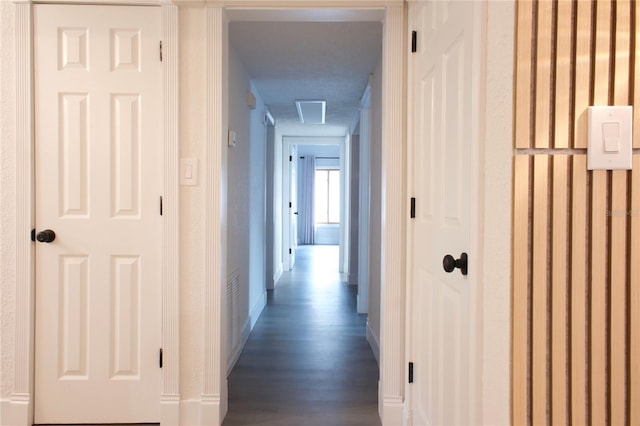 hall with dark wood finished floors and baseboards