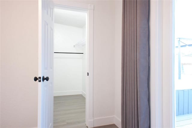 hallway with light wood-style floors and baseboards