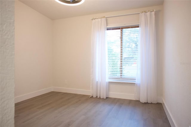 unfurnished room featuring wood finished floors and baseboards