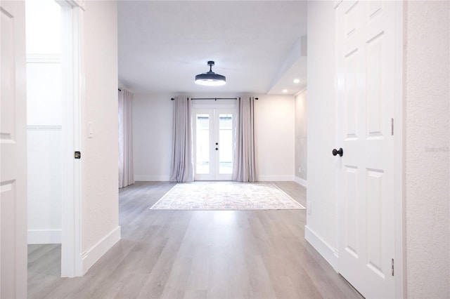 foyer featuring french doors, light wood-type flooring, and baseboards